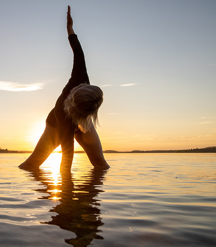 Photo of woman in yoga twist standing in the lake for Auburn Yoga & Fitness home page display